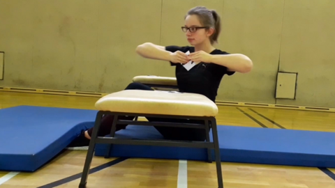 Das Bild zeigt eine Frau beim Ausführen von schrägen Sit-Ups mit einem Puzzleteil in der Hande